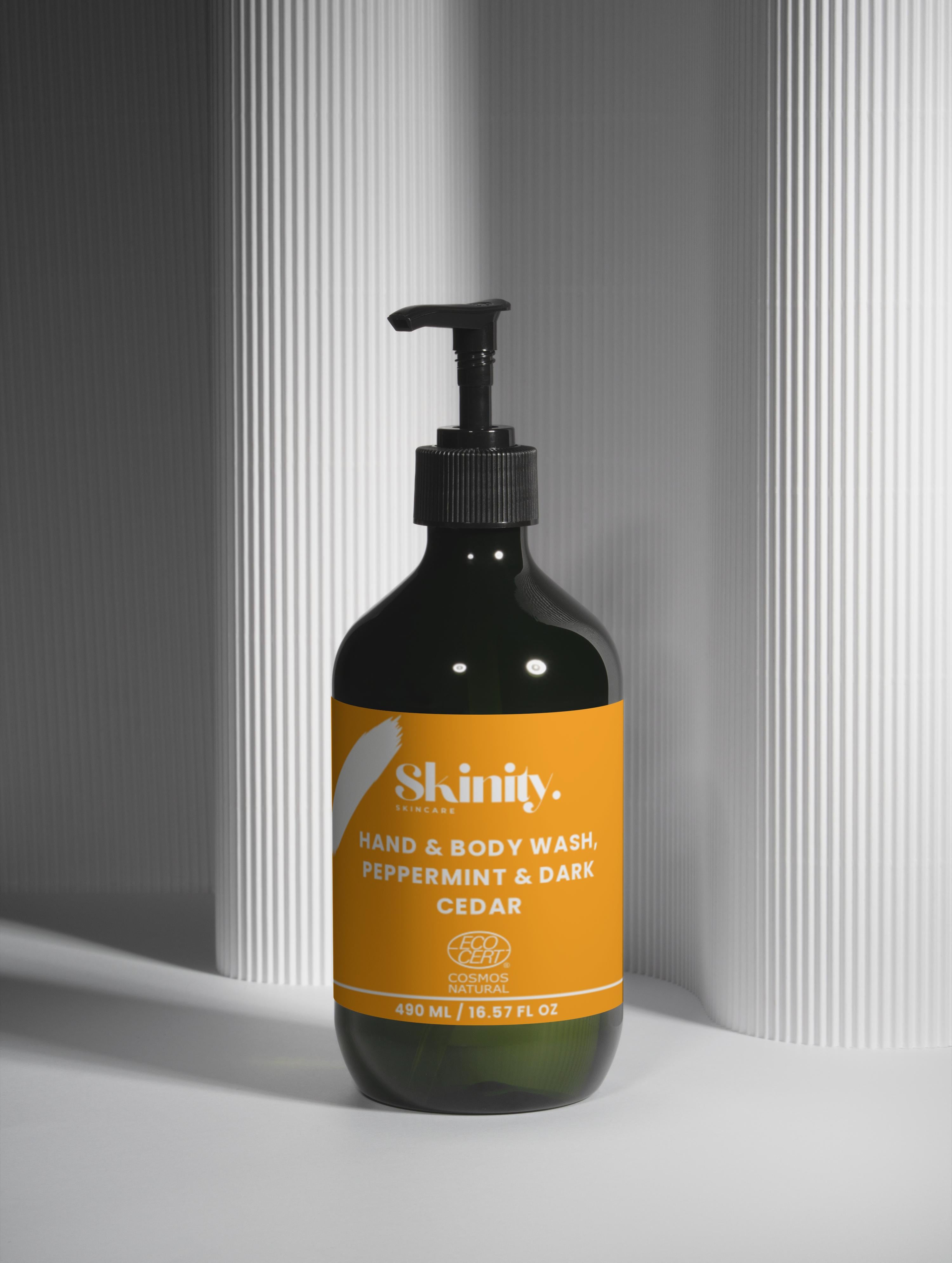 Hand and Body Wash Peppermint and Dark Cedar bottle displayed on a textured background, highlighting its fresh scent.