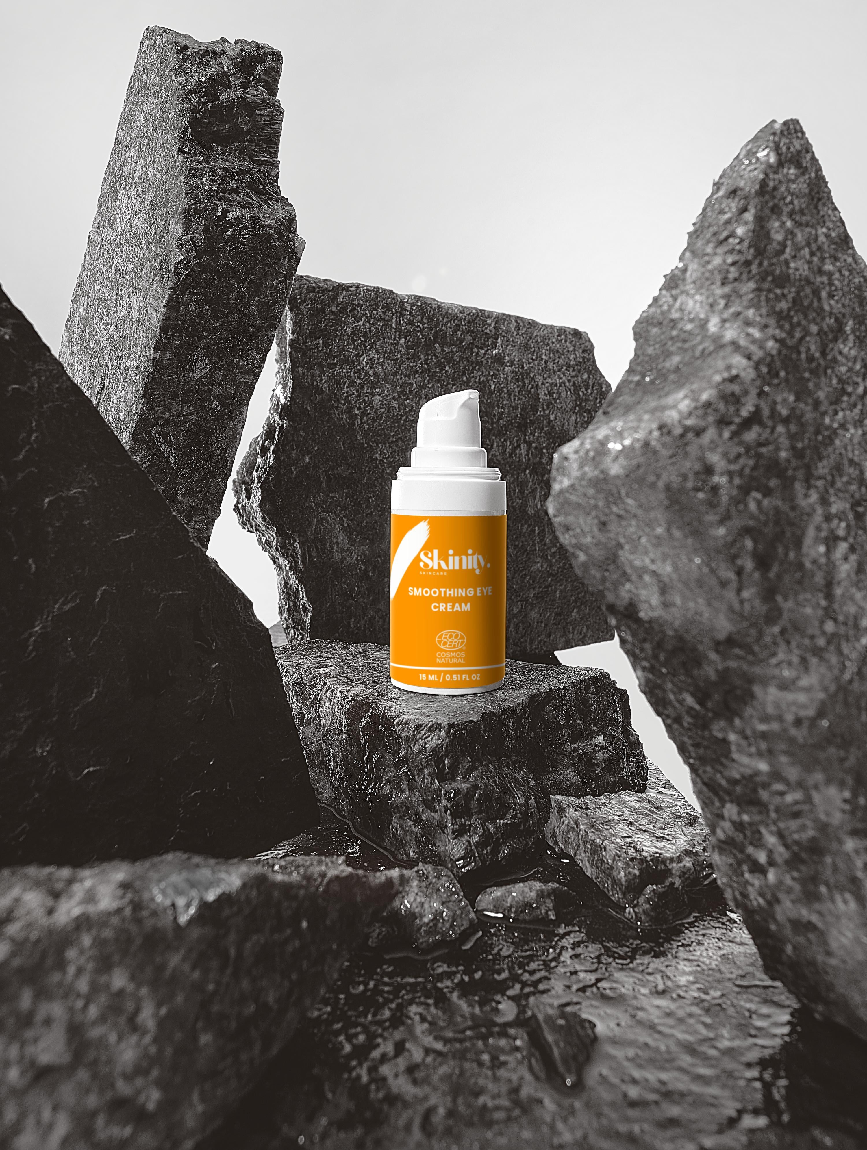Smoothing eye cream product displayed among textured rocks, showcasing its hydrating benefits for all skin types.