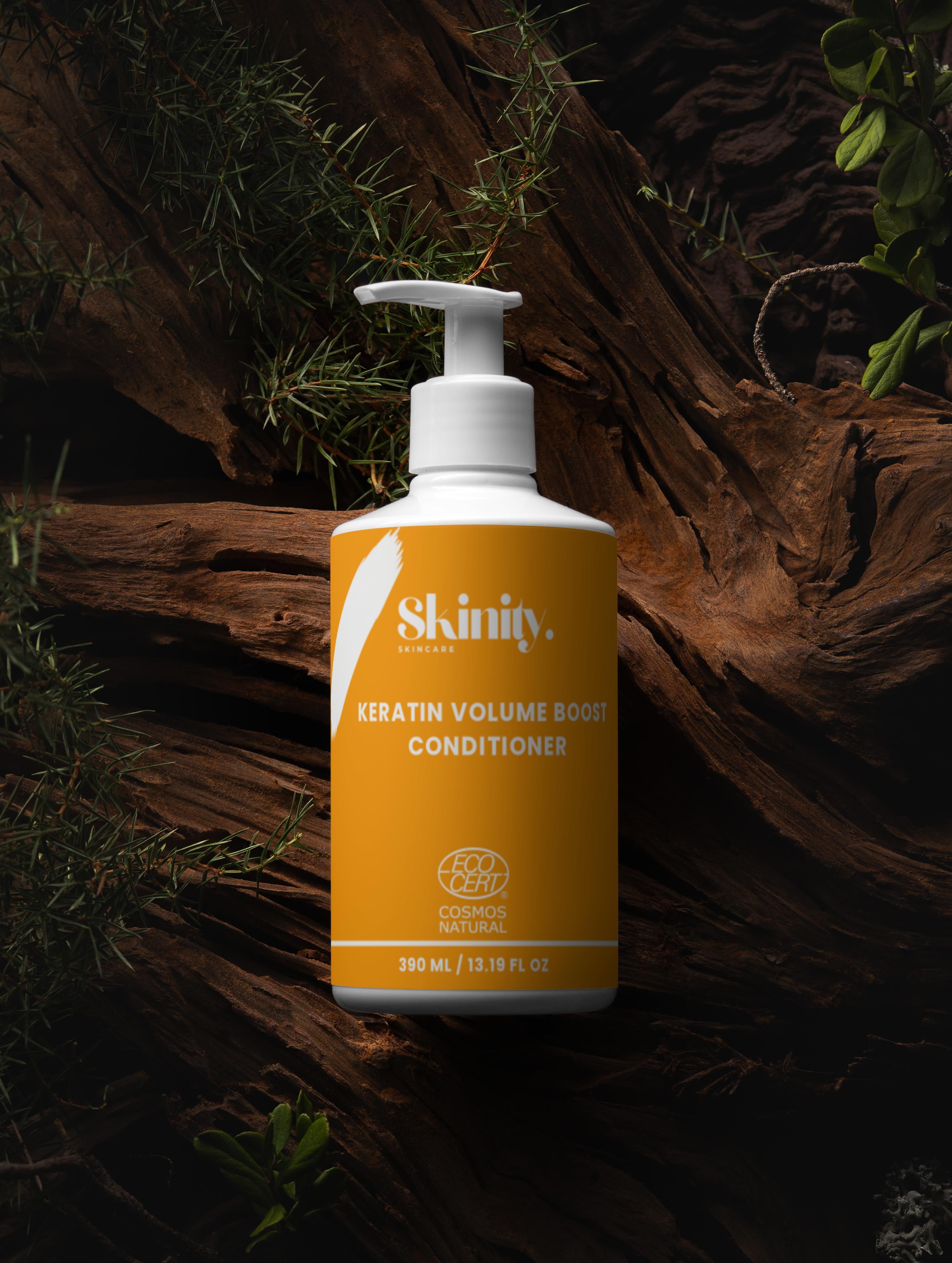 Keratin Volume Boost Conditioner bottle on wooden background with greenery, promoting fuller and manageable hair.