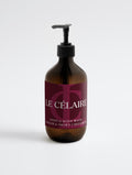 A bottle of Le Célaire Hand & Body Wash in a dark amber glass bottle with a black pump dispenser and a deep burgundy label, set against a clean white background.