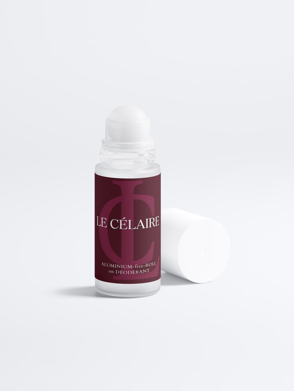 A roll-on deodorant bottle with a white cap and a dark burgundy label reading 'LE CÉLAIRE', shown on a clean white background with the cap placed beside the bottle.