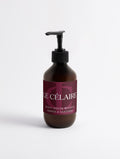 An amber glass pump bottle of Le Célaire Silk Skin Body Serum with a black pump and a dark burgundy label, set against a clean white background.