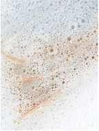 Bubbles and foam from Sensitive Scalp Shampoo for all Hair Types on a soft background.