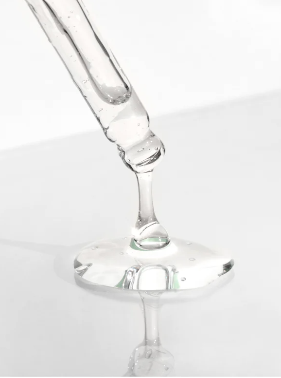Caffeine Gel Booster for All Skin being dispensed from a dropper, showcasing its clear gel texture.