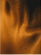 Close-up image of silky textured fabric with warm tones, highlighting the smooth and soft appearance of the material.