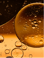 Close-up of golden oil droplets and bubbles, representing Omega 6-9 Glowing Skin Body Oil For All Skin Types.