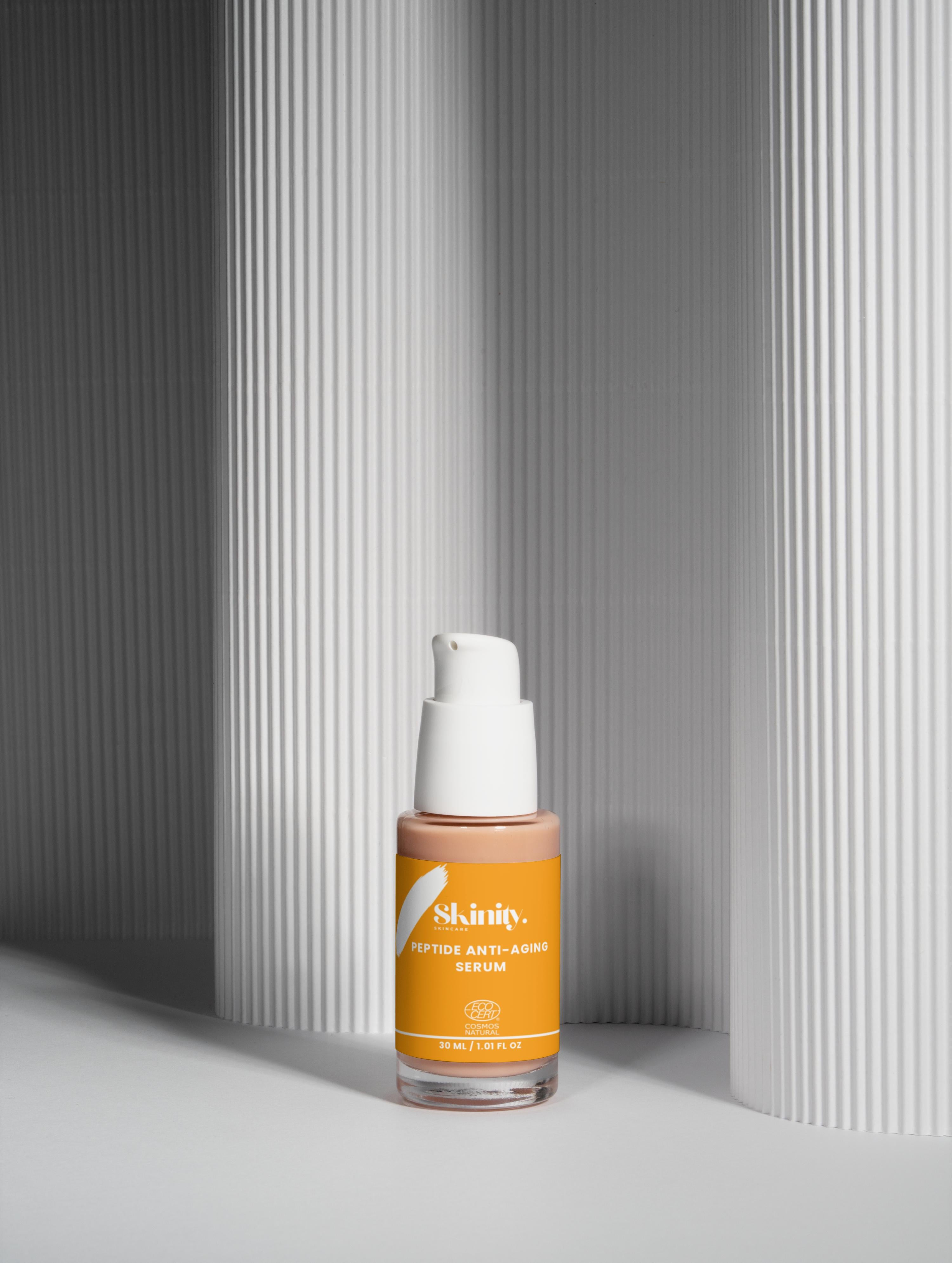Peptide Anti-Aging Serum for All skin in a sleek bottle against textured background.
