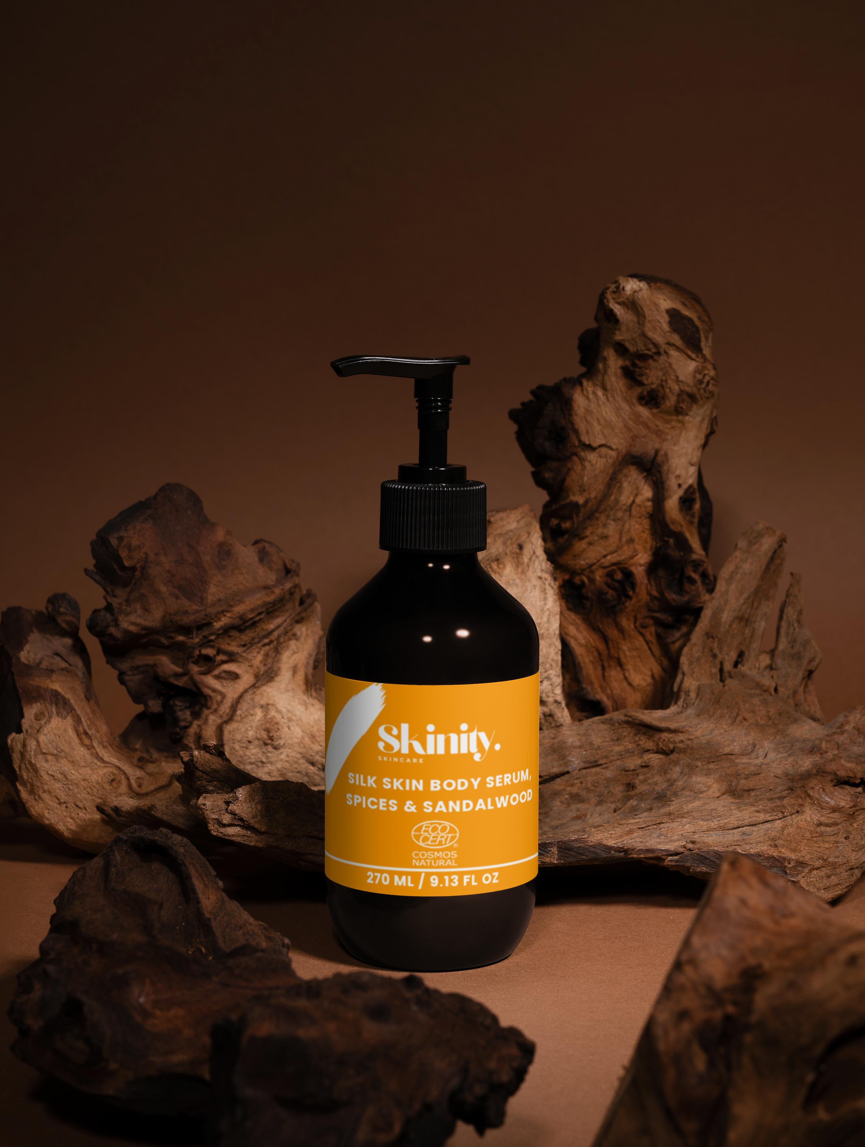Silk Skin Body Serum Spices And Sandalwood bottle on wooden background, showcasing its nourishing formula.