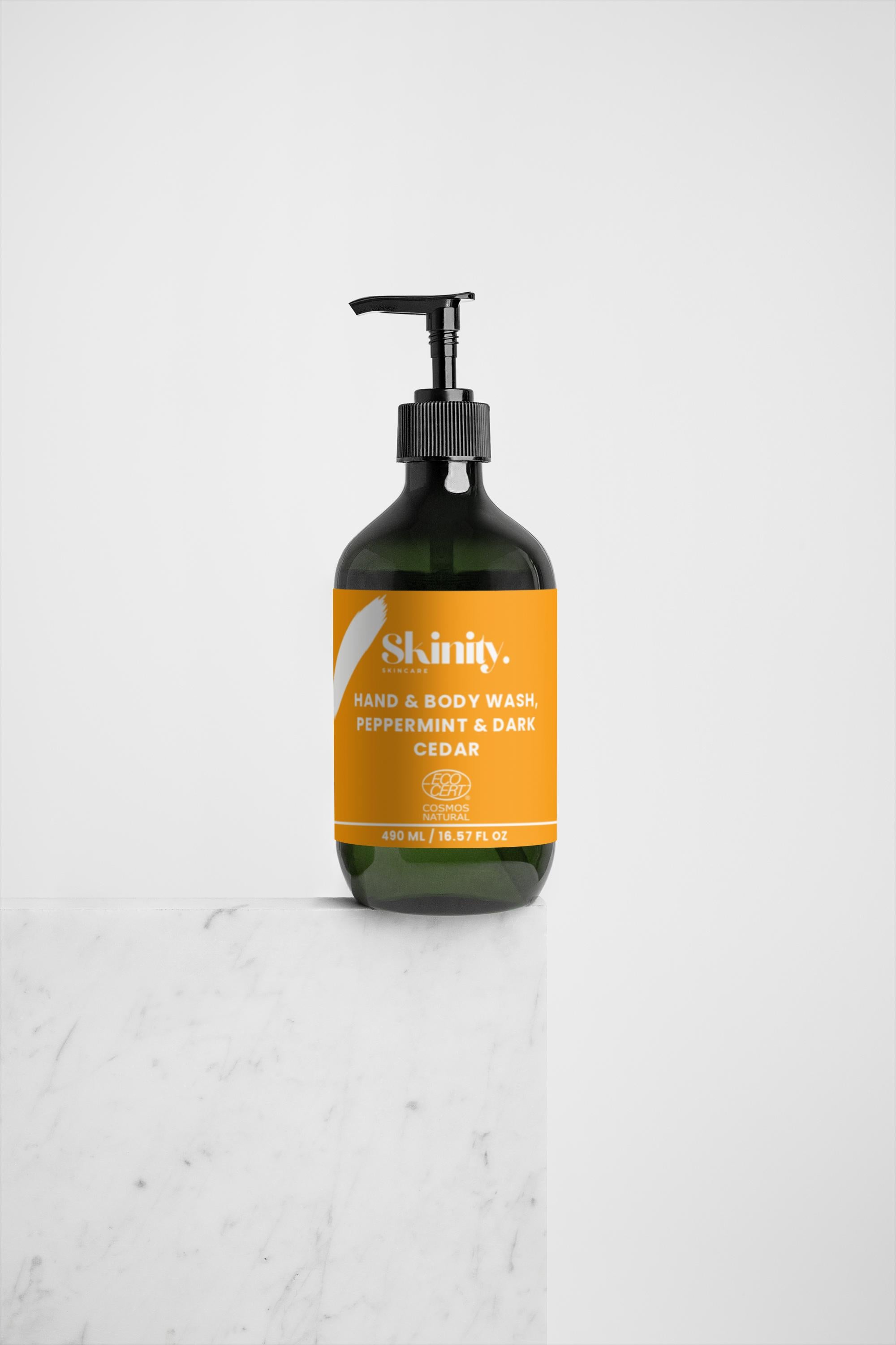 Hand and Body Wash Peppermint and Dark Cedar bottle on marble background.