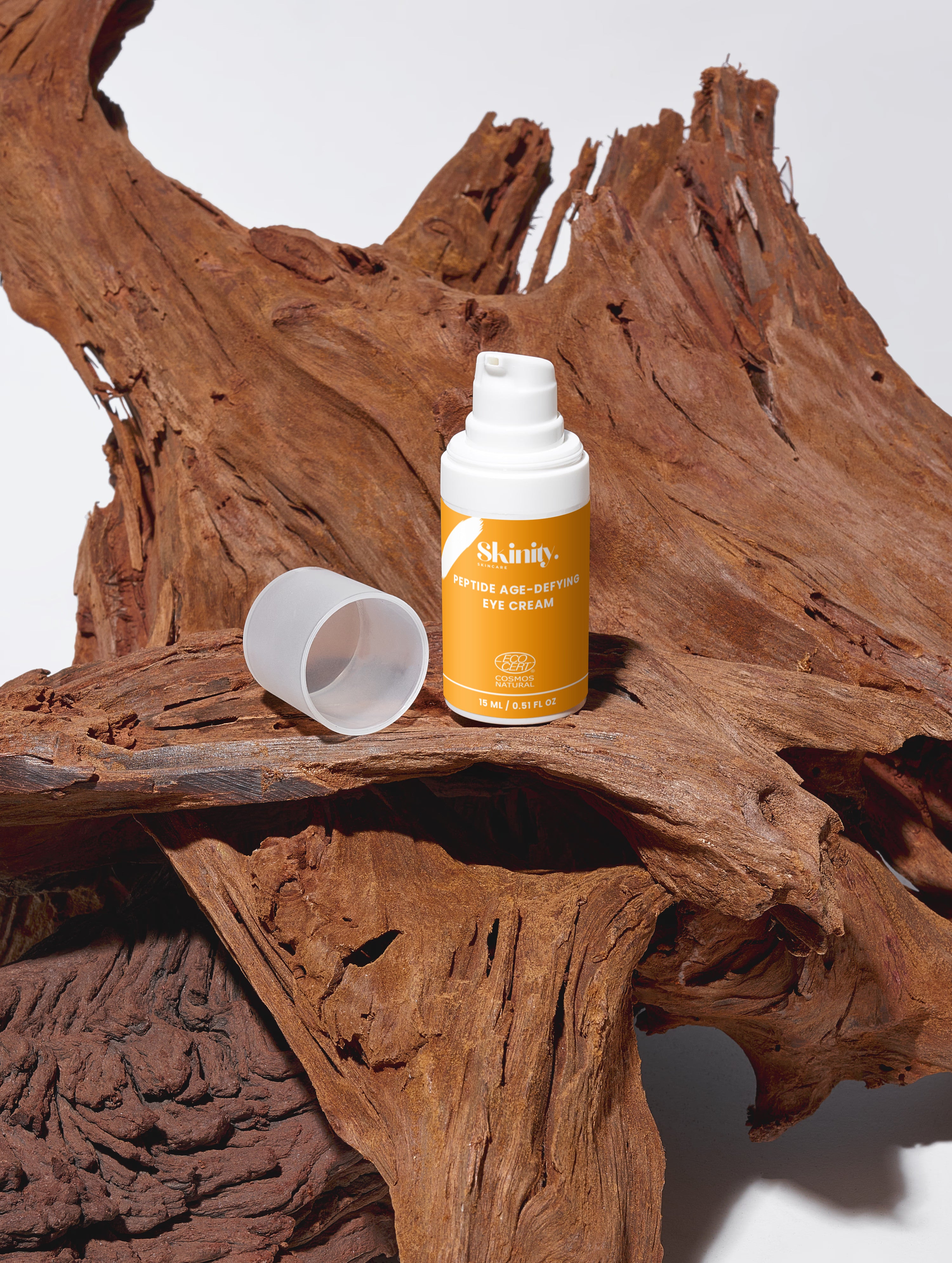 Skinity Skincare Peptide Anti Aging Eye Cream for Wrinkles and Dark Circles premium product bottle placed on an organic luxury dark wood texture background with natural greenery elements