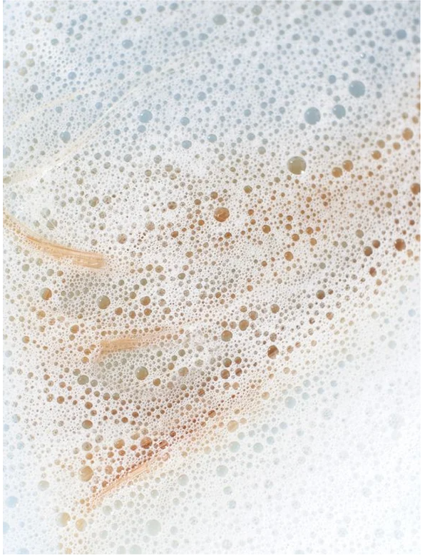 Bubbles and foam from Sensitive Scalp Shampoo for all Hair Types on a soft background.