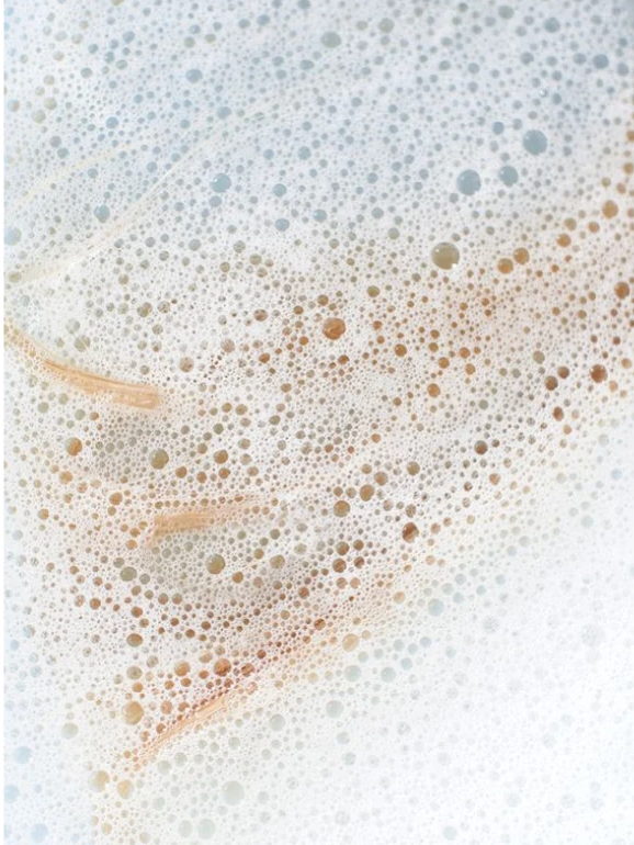 Close-up of bubbles from Colour Care Shampoo Peachy Grapefruit Zest, highlighting its gentle formula for vibrant hair.