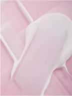 Smoothing eye cream texture spread on a pink surface, showcasing its silky and hydrating properties.