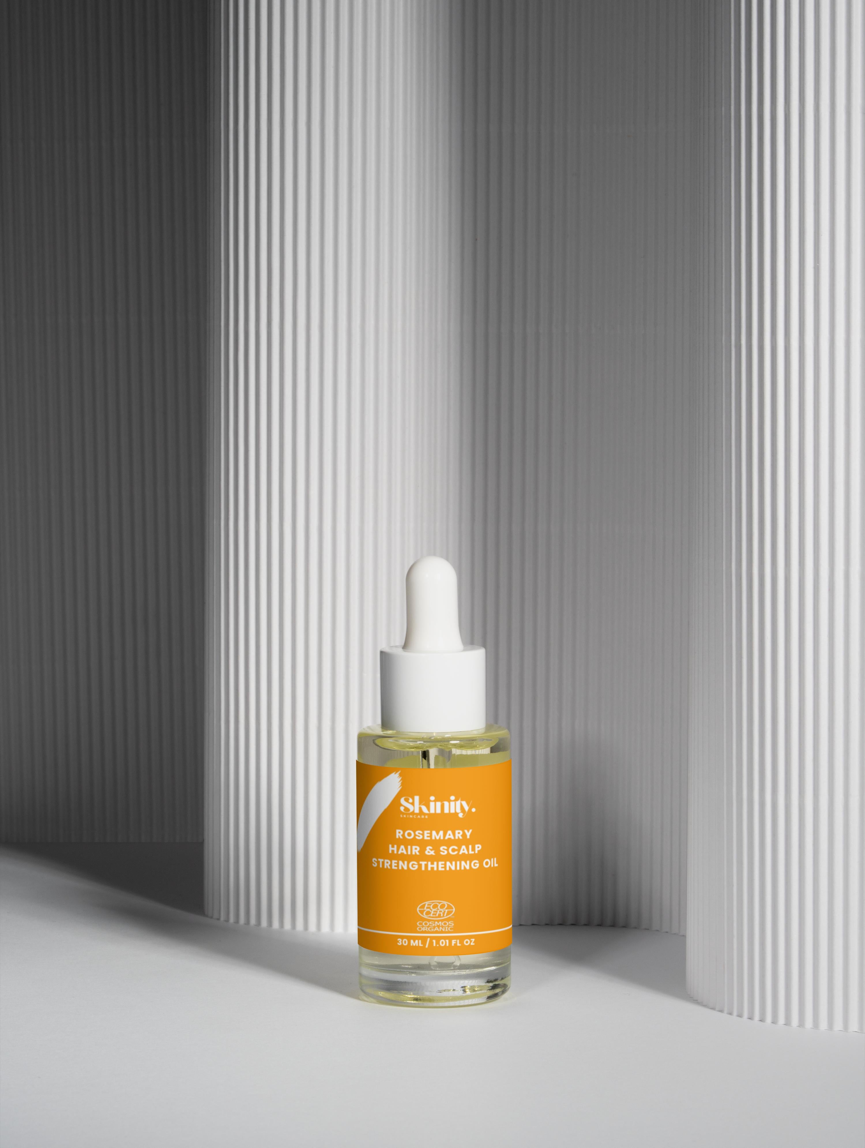 Rosemary Hair And Scalp Strengthening Oil in a glass bottle with a dropper, promoting revitalized hair.