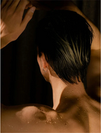 Man with wet hair in shower, showcasing the use of Deep Cleanse Scalp Scrub Rosemary and Mint for a refreshed scalp.