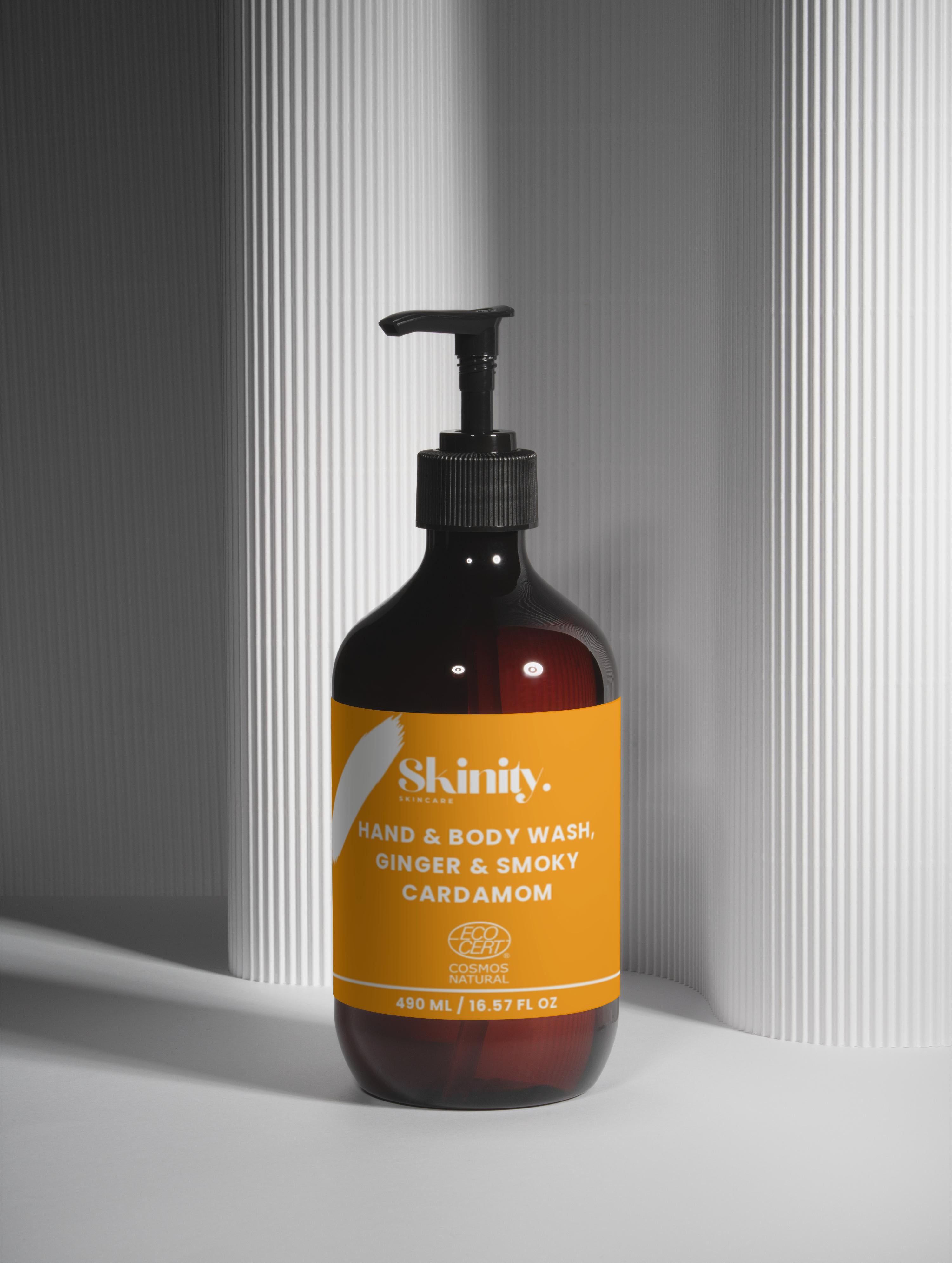 Hand and Body Wash Ginger and Smoky Cardamom in a sleek bottle with pump on textured background.