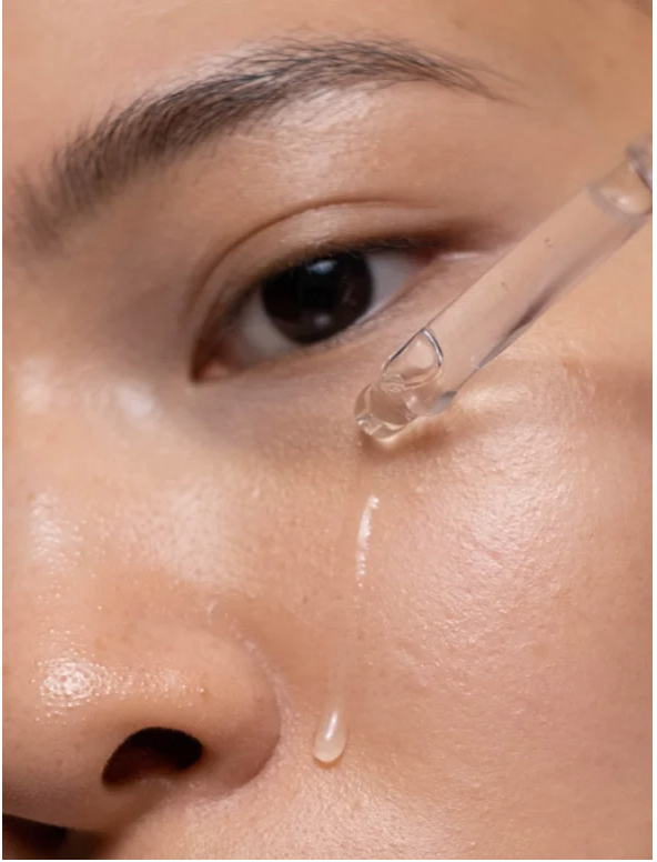 AHA Peeling Concentrate For Skin being applied to a woman's cheek for brighter, smoother skin.