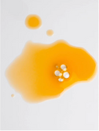 All-In-One Facial Oil for all skin, a luxurious product in a vibrant yellow oil drop on a white surface.