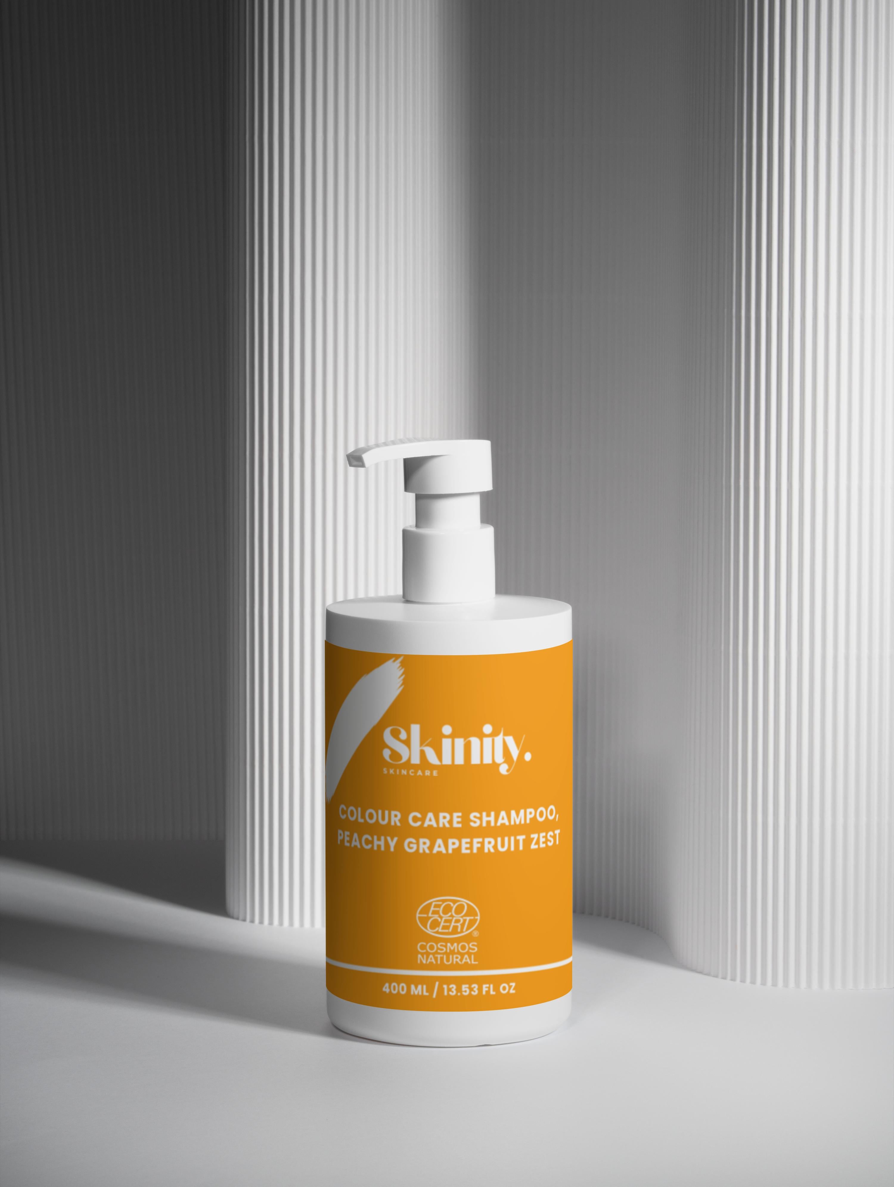 Colour Care Shampoo Peachy Grapefruit Zest bottle displayed on a minimalist background with a pump top.