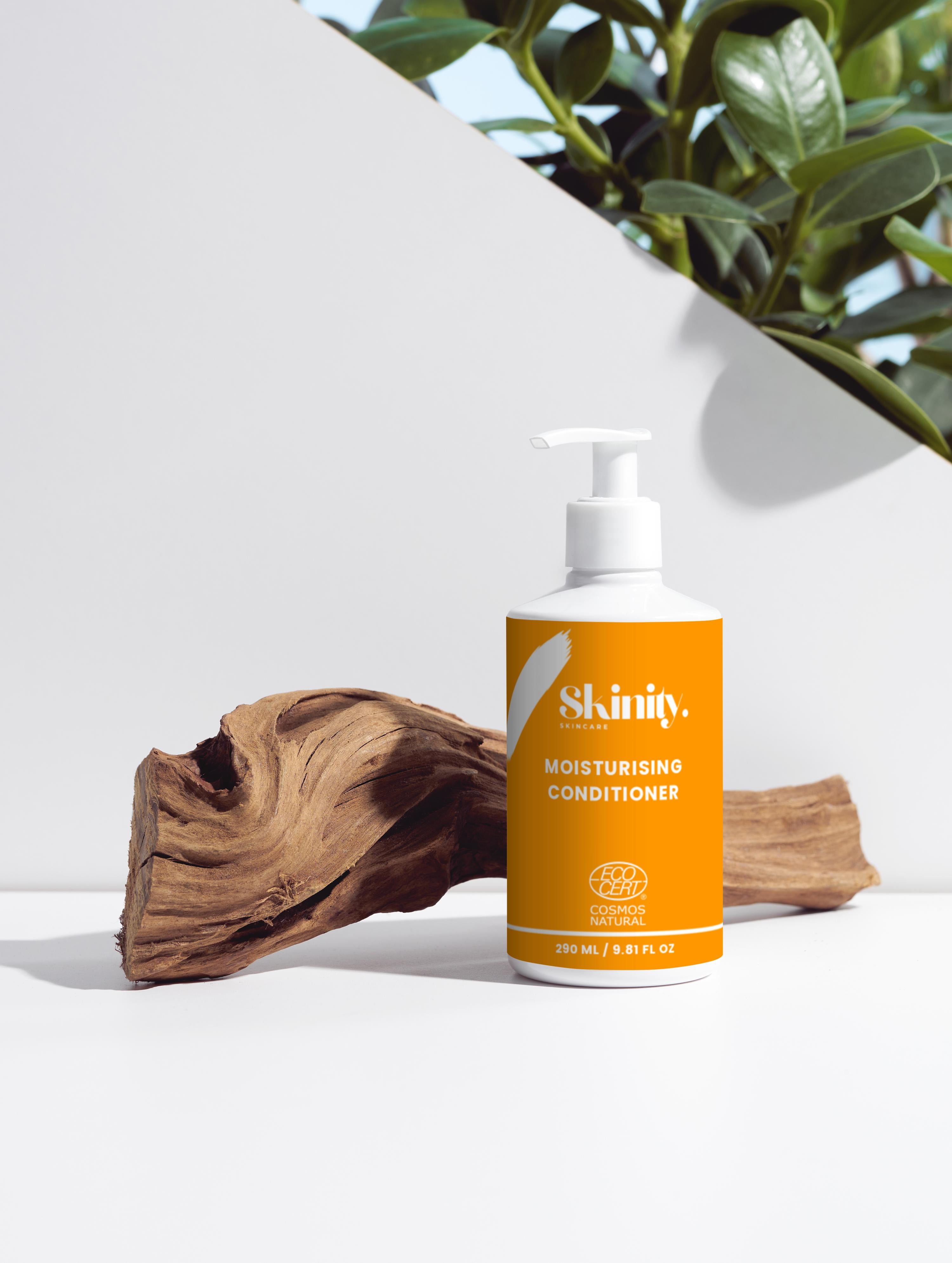 Moisturising Conditioner for all Hair Types bottle on a wooden surface with plants in the background.