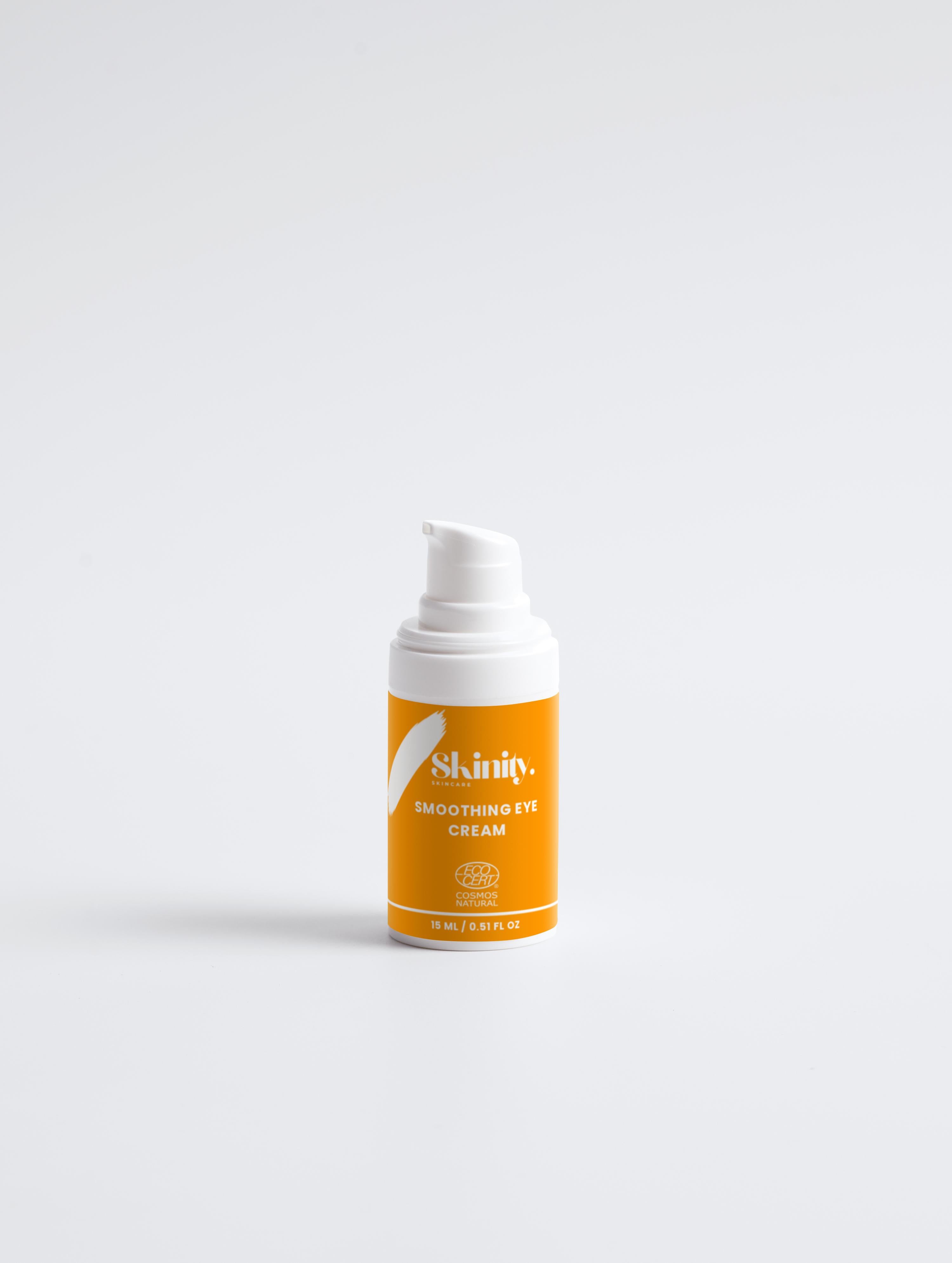 Smoothing eye cream bottle with an orange label on a white background, designed for all skin types.