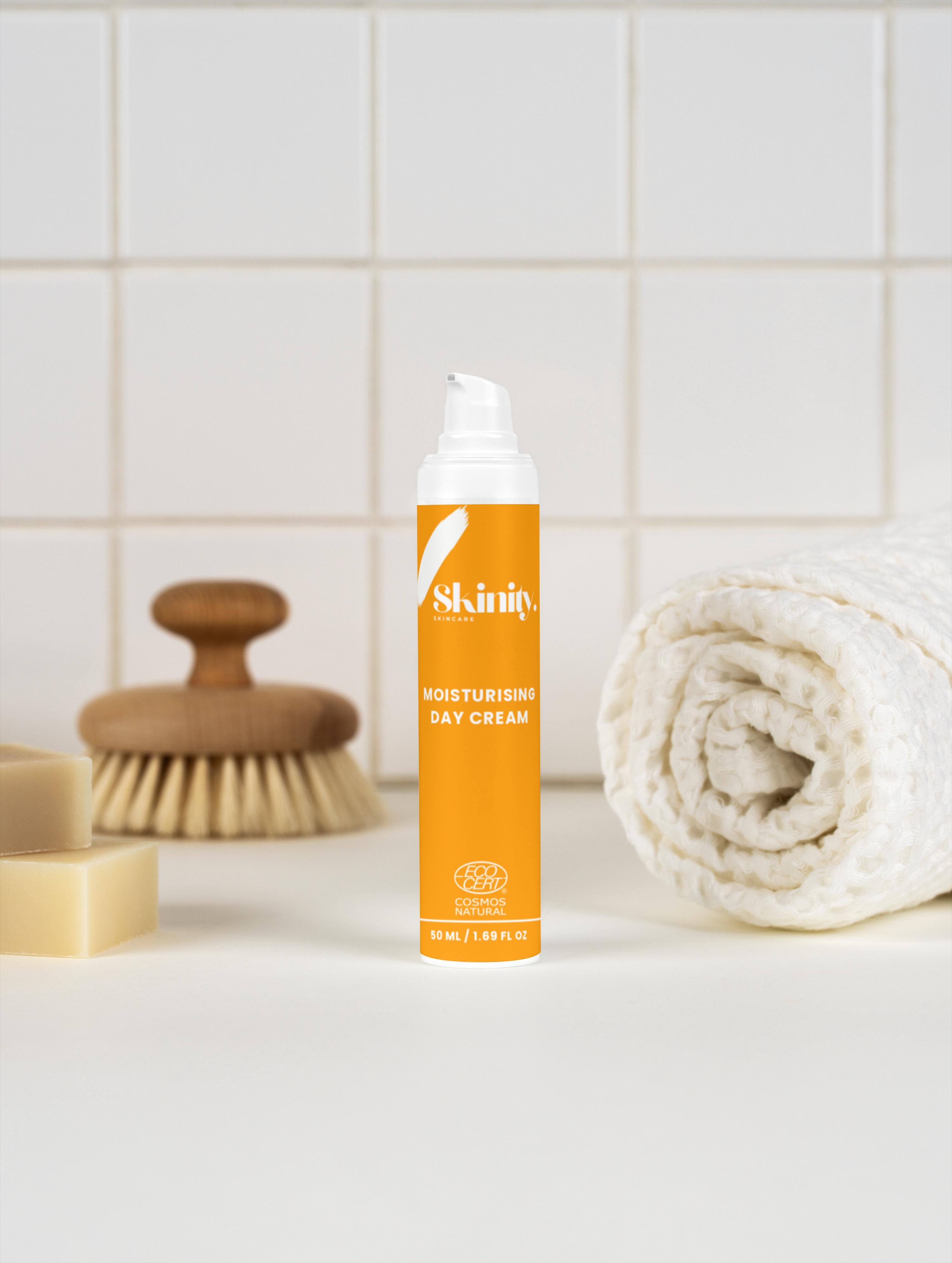 Moisturising Day Cream For All Skin in a stylish pump bottle, surrounded by soft towels and bath accessories.